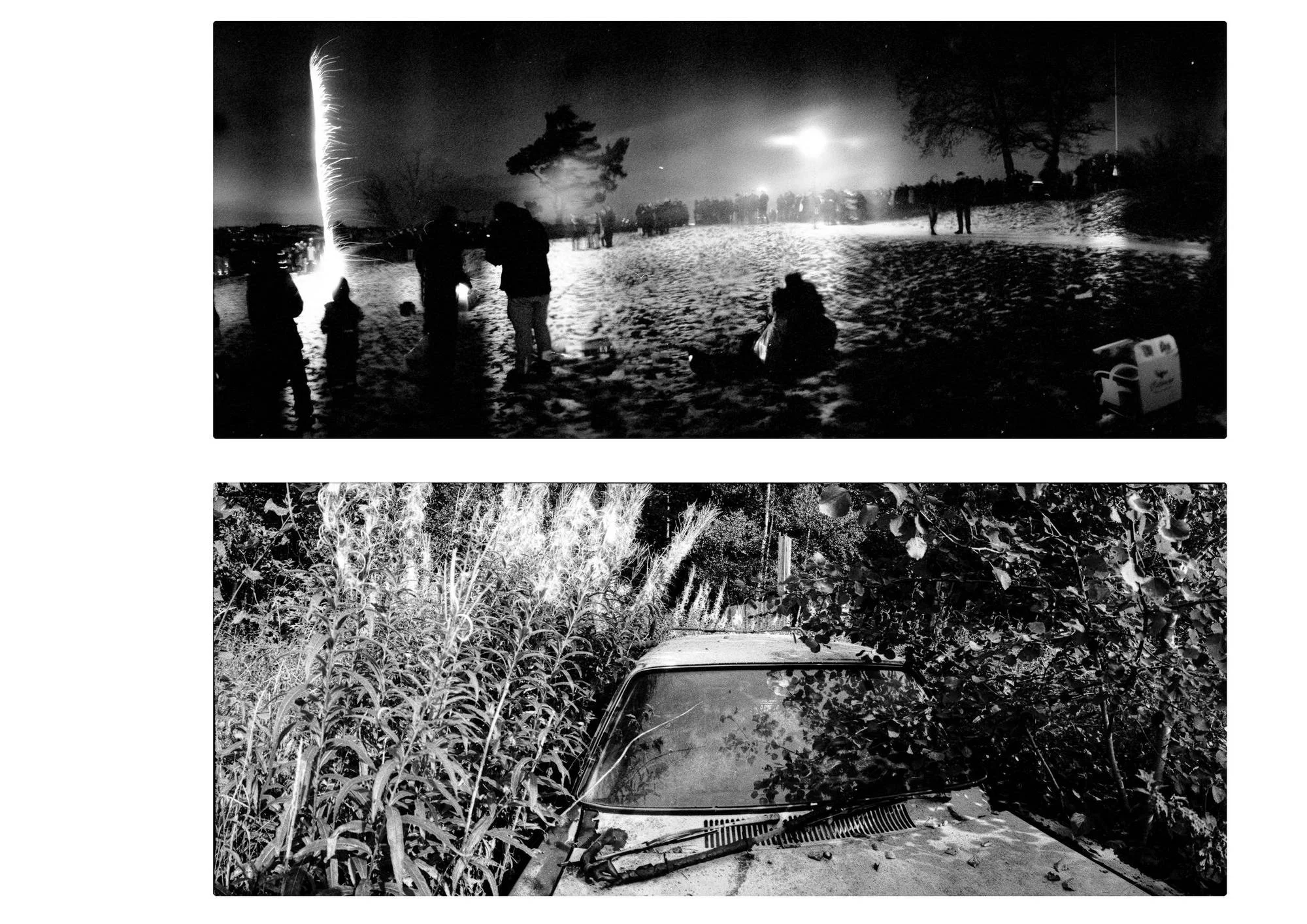 Two black-and-white panoramic photographs arranged vertically. The upper image shows people gathered on a snow-covered hillside at night, watching a bright vertical trail of fireworks rise into the sky. Distant lights illuminate the horizon, while several figures stand or sit in the foreground. The lower image shows the front of an old car almost completely surrounded by tall grasses, shrubs and overhanging branches, with leaves scattered across its bonnet.