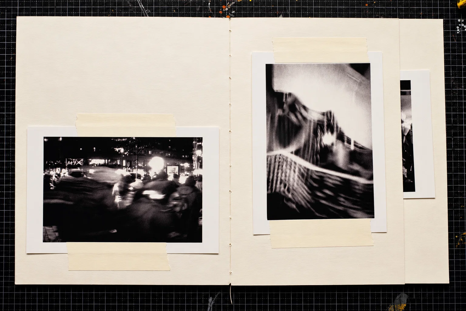 Two black-and-white photographs. On the left, blurred pedestrians move through a brightly lit street at night. On the right, a close-up of dark fabric and pale, streaked forms creates an almost abstract composition.